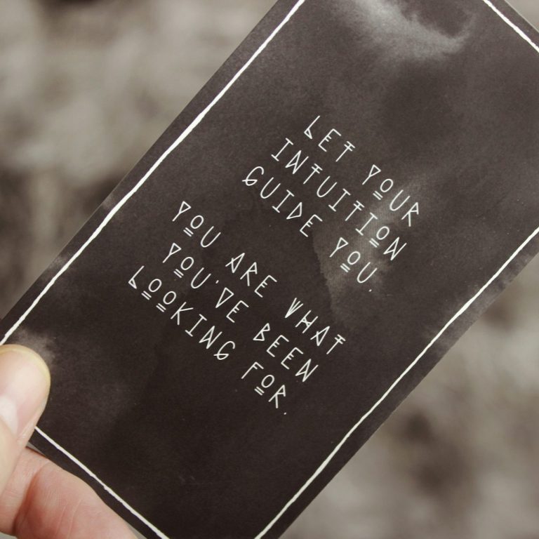 A black card with white text reading, 'Let your intuition guide you. You are what you've been looking for,' symbolizing inner wisdom